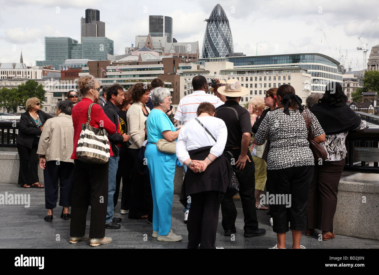 Les touristes réunis autour de leur guide par Tamise, Londres Banque D'Images