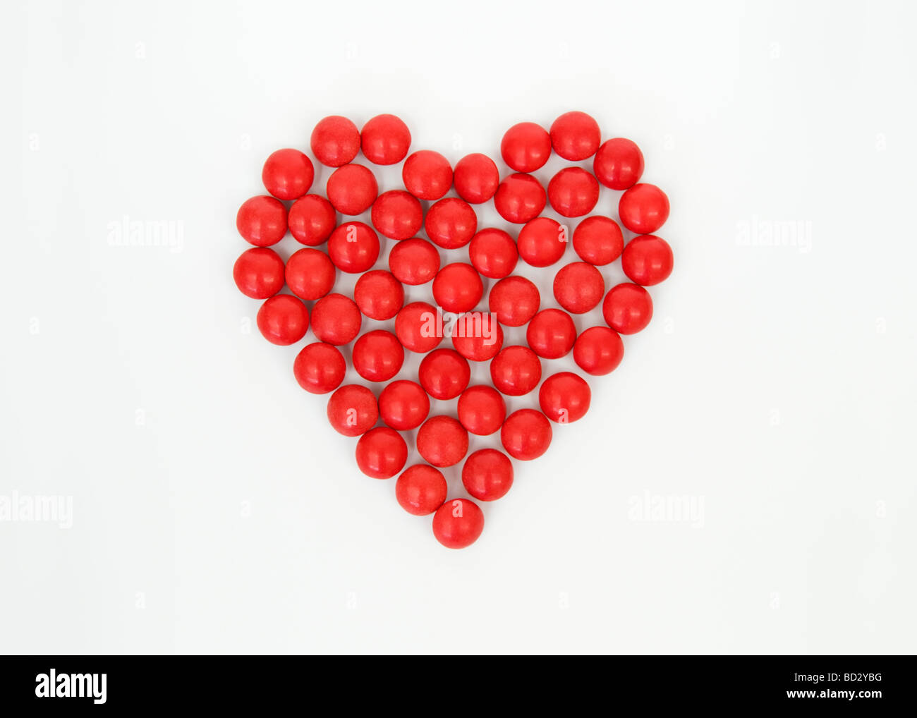 La vie toujours tourné artistique de l'ensemble des bonbons rouges en forme de coeur prises sur un fond blanc. Banque D'Images