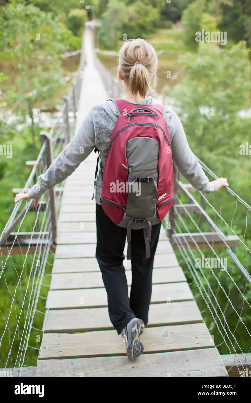 Femme randonneur sur un pont suspendu oscillant, souris, Manitoba, Canada. Banque D'Images