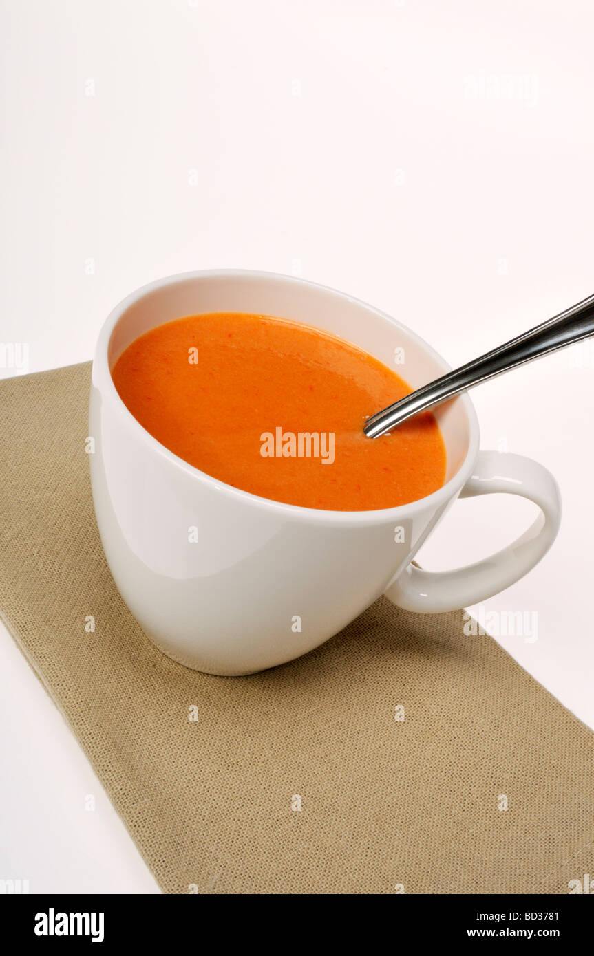 Tasse de soupe aux tomates avec cuillère et serviette Banque D'Images