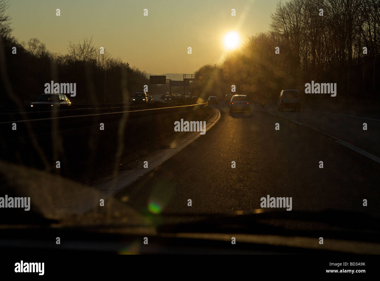 Conduire dans un coucher de soleil sur l'Autobahn, Rhénanie du Nord-Westphalie, Allemagne. Banque D'Images
