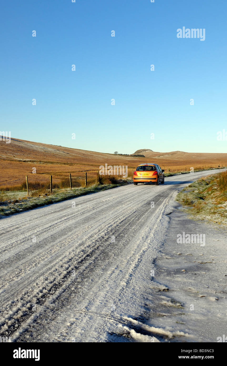 Voiture qui roule sur la neige sur la route est tombé dans l'Harter Lake District National Park Banque D'Images