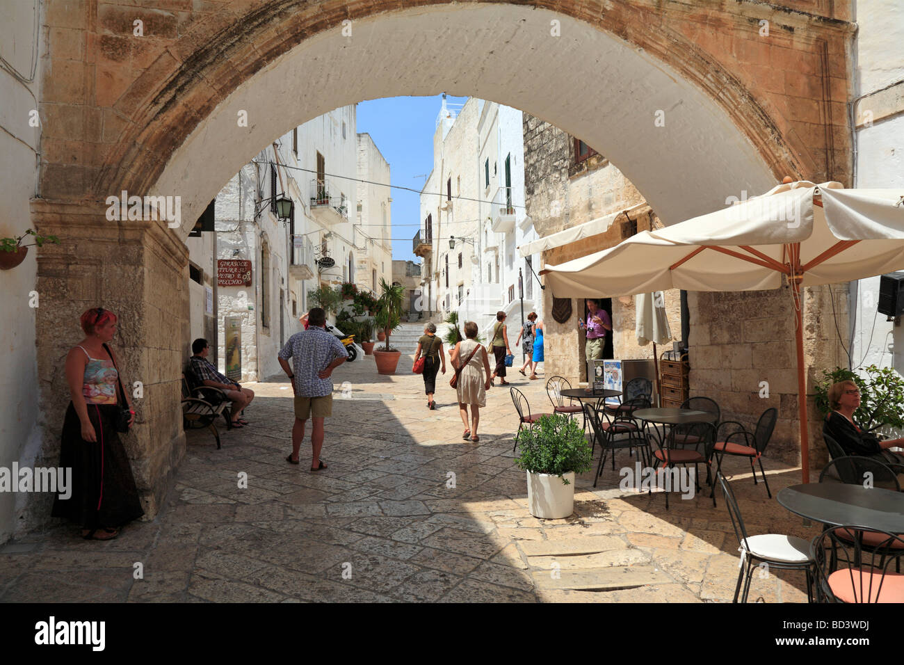 Les touristes dans une rue du Centro Storico, Ostuni, Pouilles, Italie. Banque D'Images