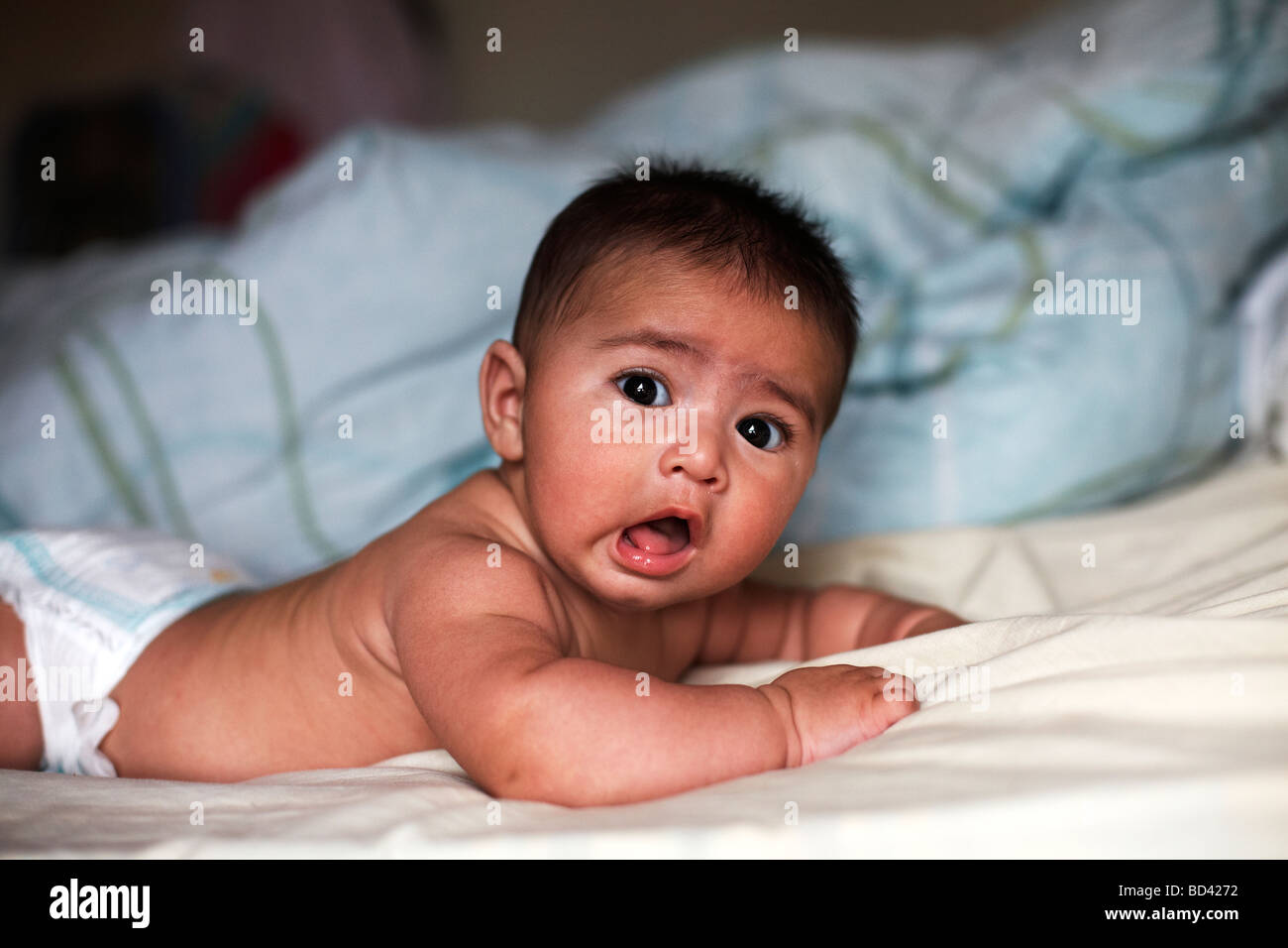 Une race mixte bébé allongé sur un lit dans sa commode à langer Banque D'Images Une race mixte bébé allongé sur un lit dans sa commode à langer Banque D'Images
