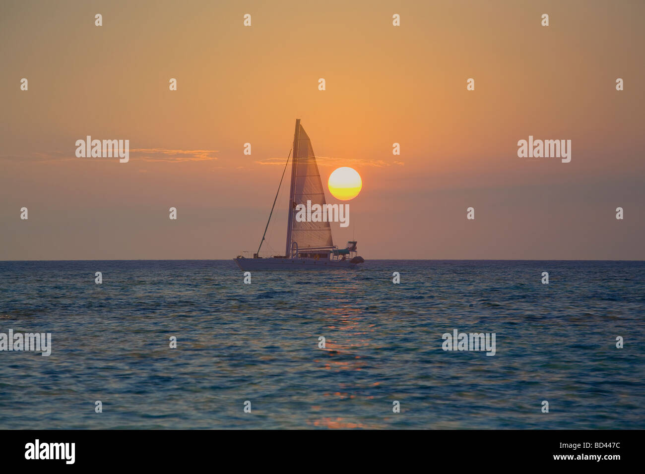 Voilier contre le lever du soleil, l'île de Roatan, Honduras Banque D'Images