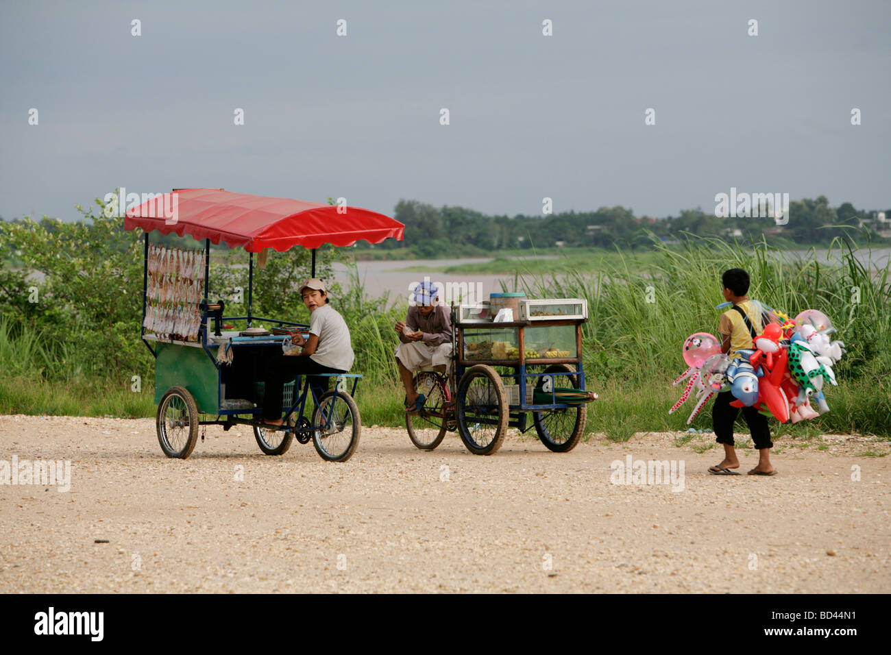 Vientiane, Laos, 2006 : attendre que les clients vendeurs d'aliments sur la promenade surplombant le Mékong Banque D'Images