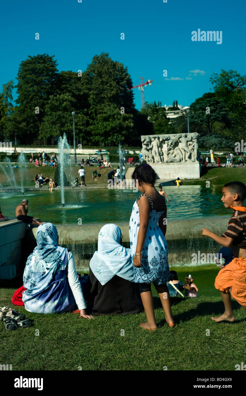 Paris France, scène de rue, famille touristique arabe, détente sur la pelouse, au Trocadéro, groupe par derrière, canicule à Paris, touristes musulmans europe Banque D'Images