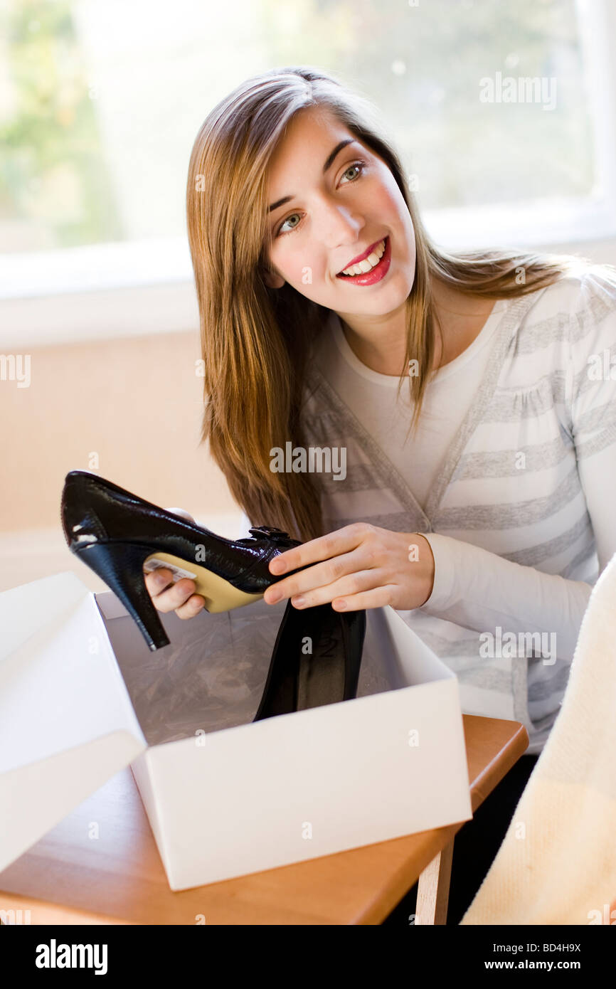 Jeune femme à la recherche très heureux de l'ouverture d'un fort avec les chaussures à l'intérieur Banque D'Images