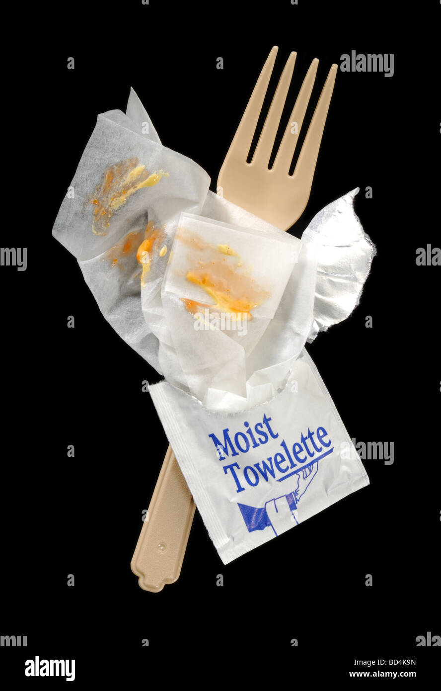 Une serviette humide avec une fourchette en plastique et les taches de moutarde Banque D'Images