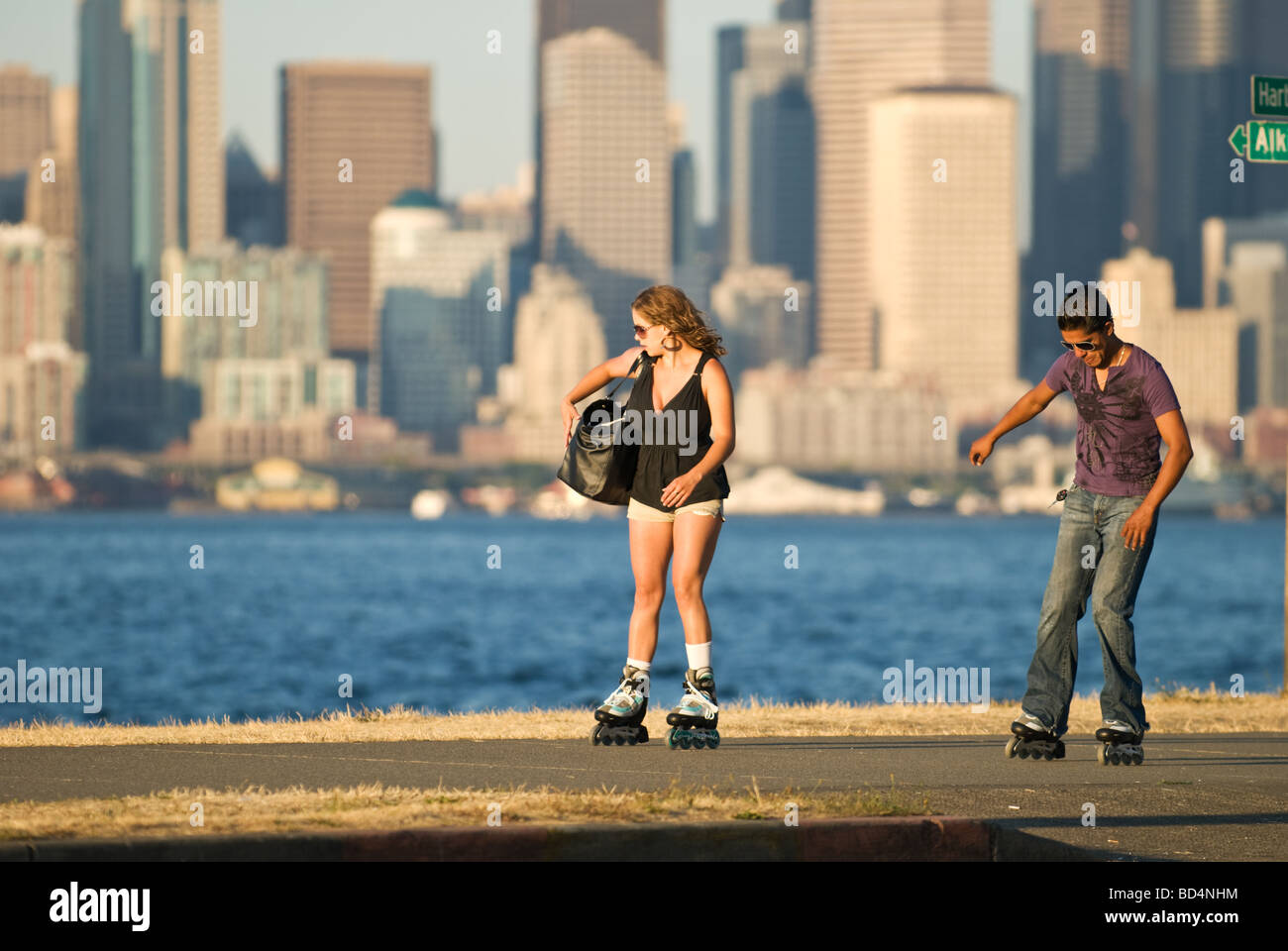 Un couple en patins à roues alignées le long de la plage Seattle Alki. Banque D'Images