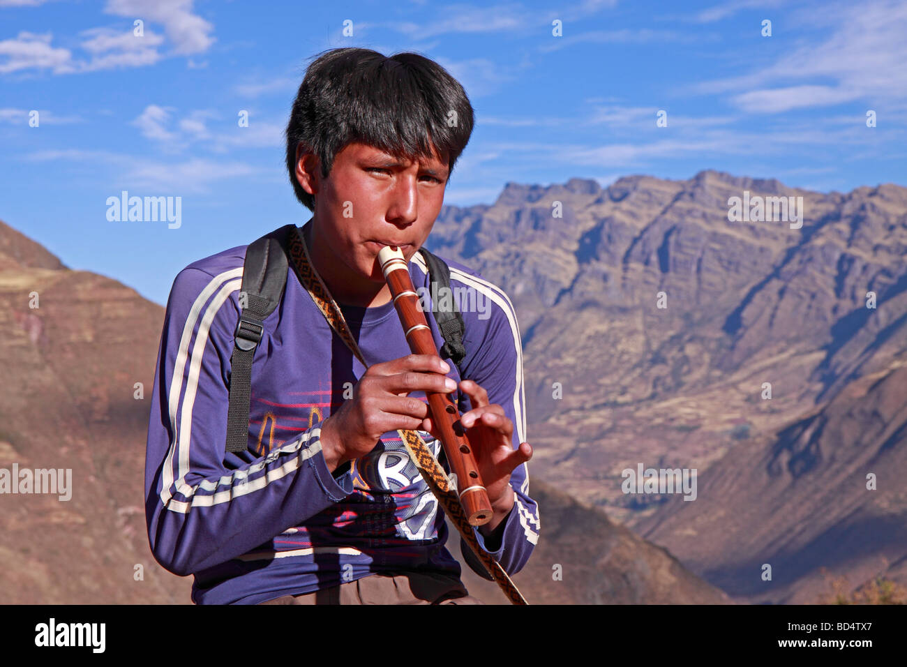 Jeune homme jouant de la flûte à côté des ruines Incas de Pisac, Pérou, Amérique du Sud Banque D'Images
