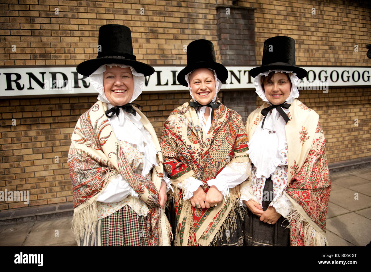 Trois femmes habillées en costume traditionnel gallois de porter Paisley châles et de grands chapeaux stovepipe Llanfair PG anglesey au nord du Pays de Galles Banque D'Images