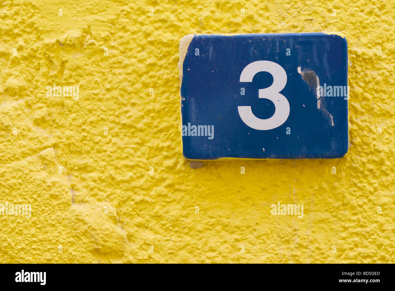 Carreaux de céramique bleu indiquant le numéro 3 sur le mur d'un bâtiment jaune à Deira, Dubaï, Emirats arabes unis (EAU) Banque D'Images