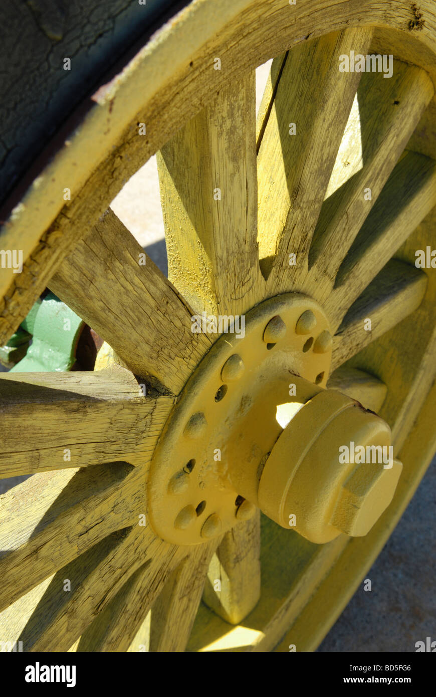 Une antique en bois du tracteur et le moyeu de roue à rayons est peint d'un jaune vif Banque D'Images