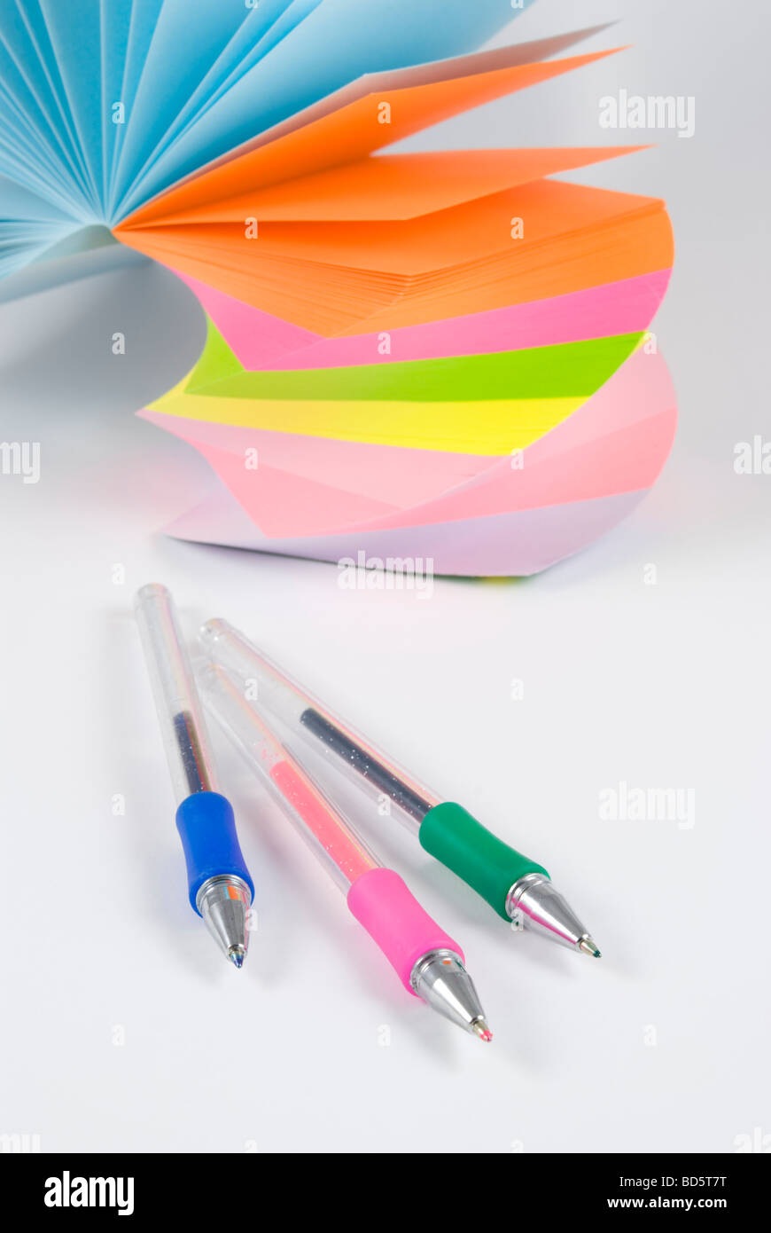 Postit notes autocollantes colorées avec trois stylos colorés studio isolé sur fond blanc Banque D'Images