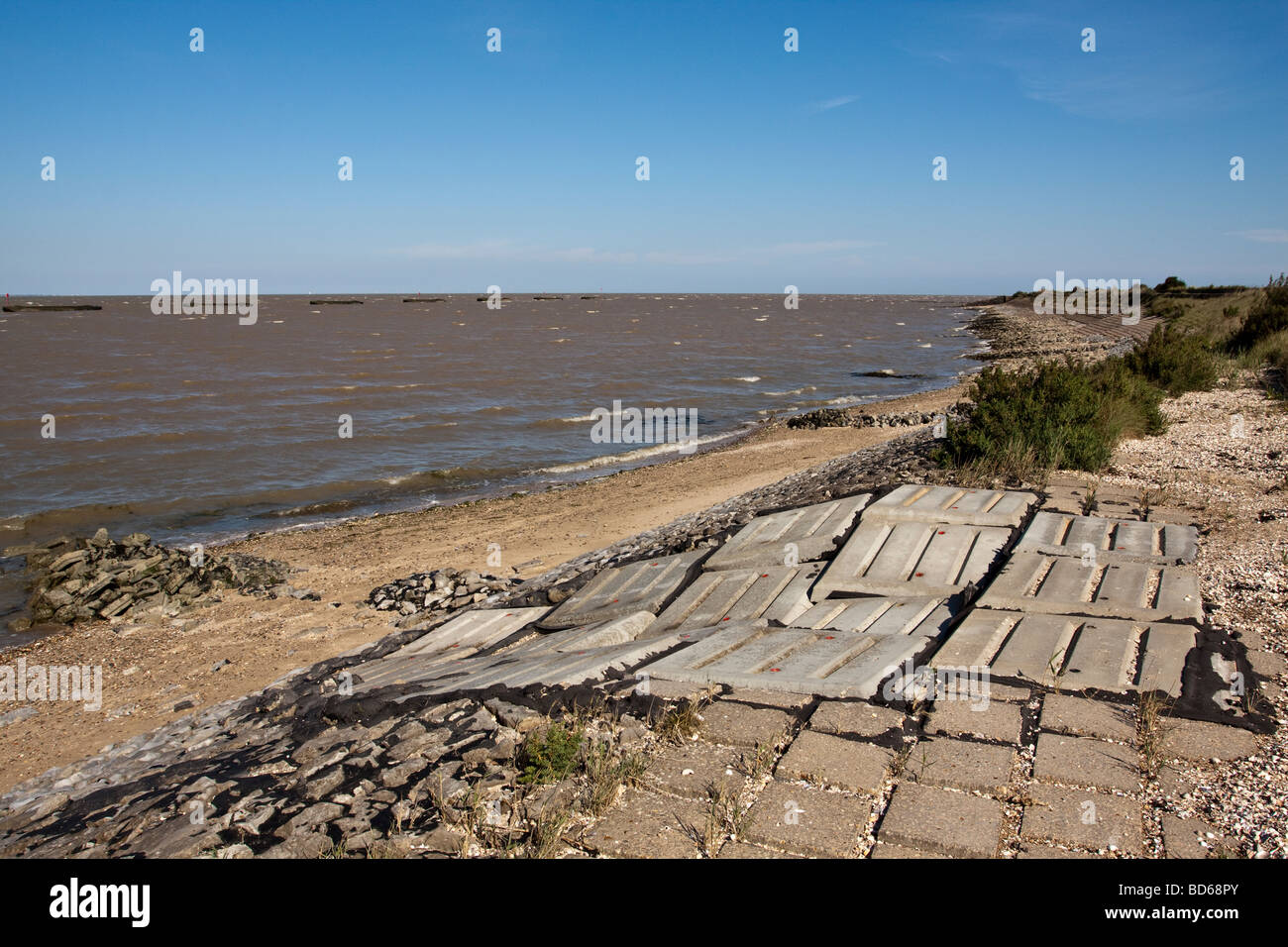 La défense côtière, Essex, Royaume-Uni. La structure du mur de béton coulé en mer et les barges au large. Banque D'Images