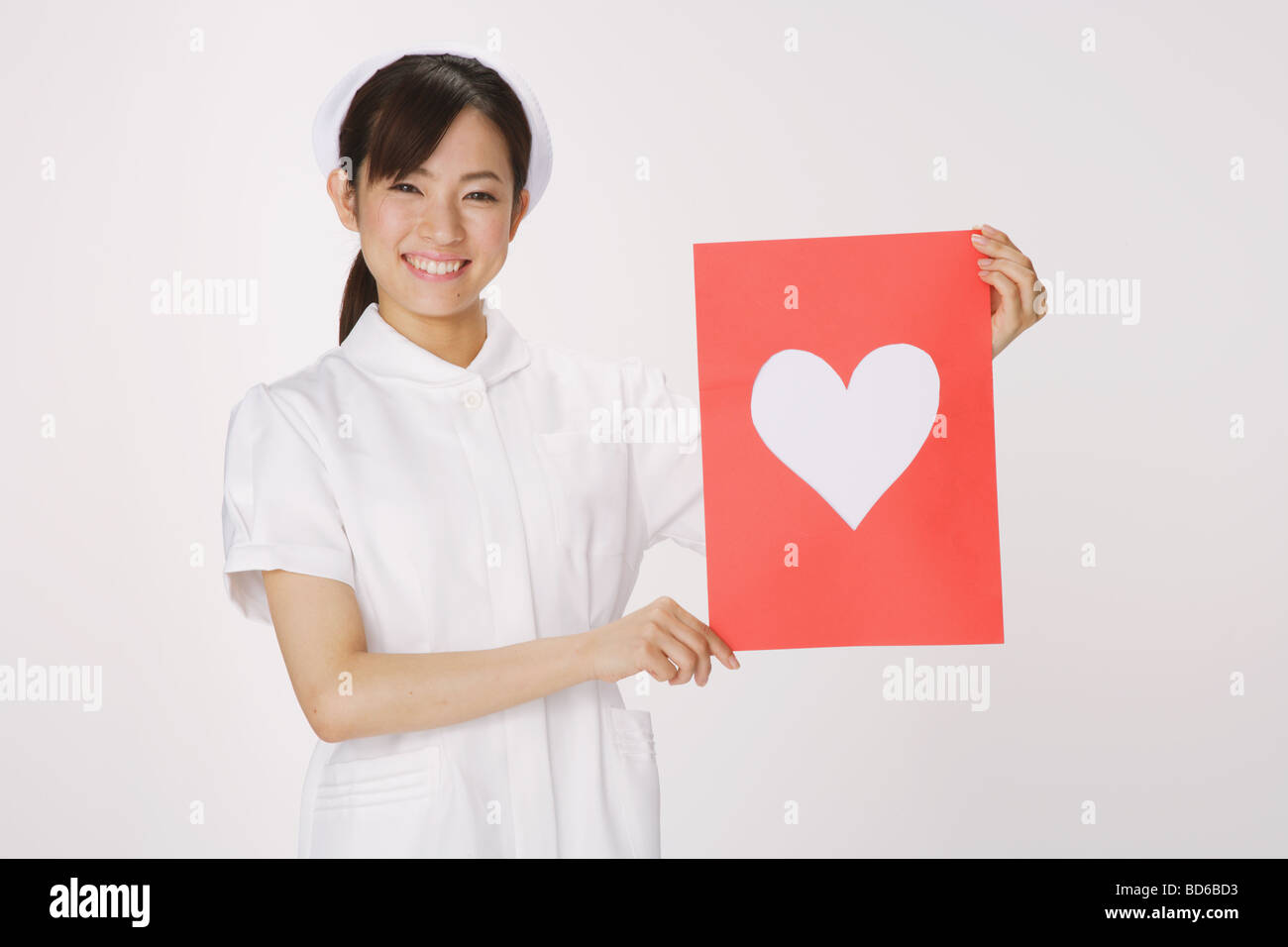 Jeune infirmière tenant un coeur Banque D'Images