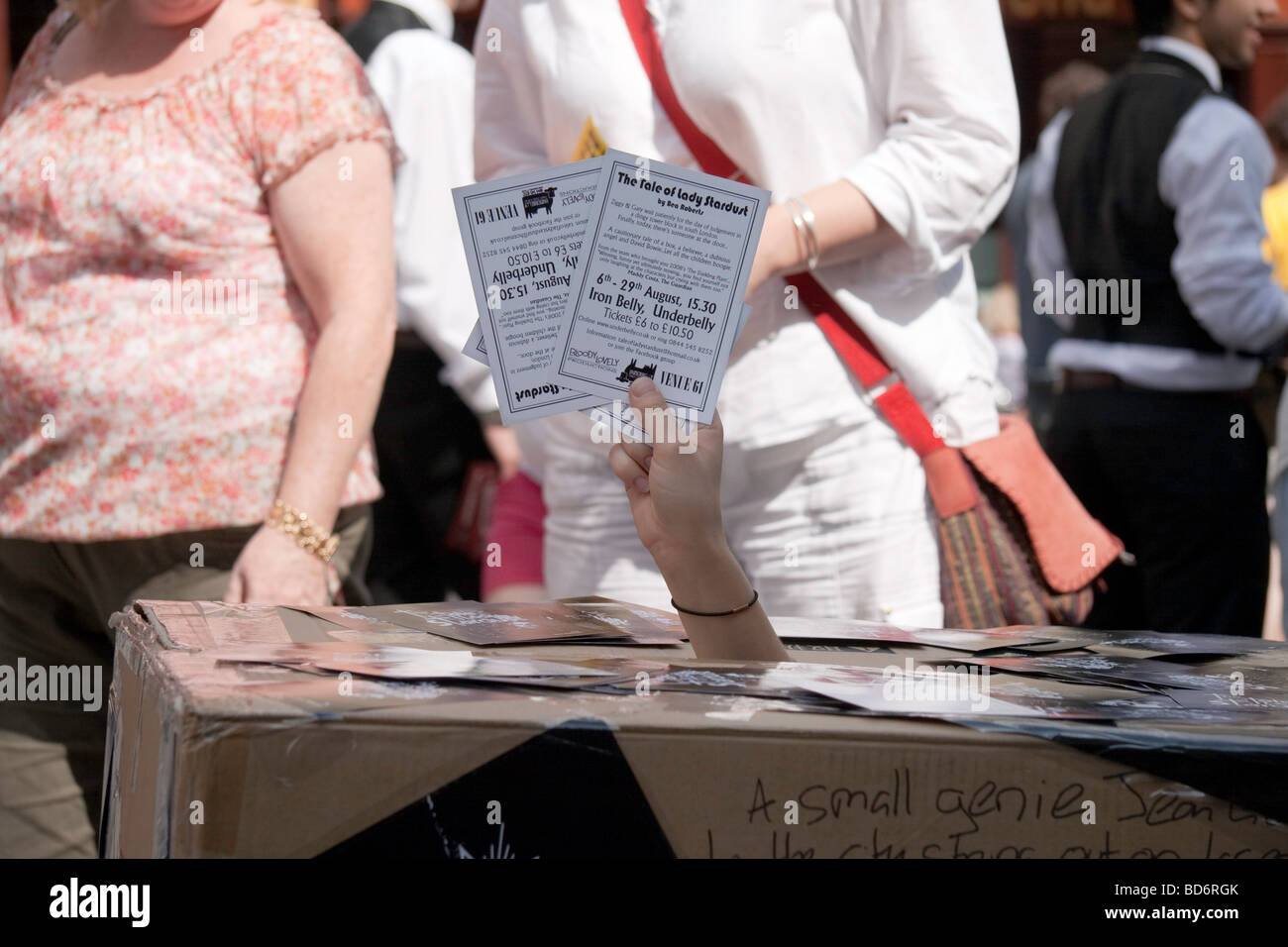 Une main qui sort d'une boîte en carton holding dépliants la promotion d'un événement pendant l'Edinburgh Fringe Festival 2009 Banque D'Images