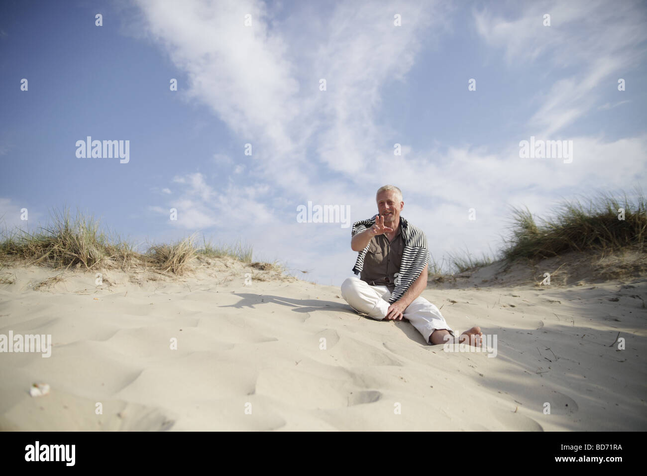 Best Ager hommes assis dans les dunes de la mer du Nord à De Haan, Belgique, Europe Banque D'Images