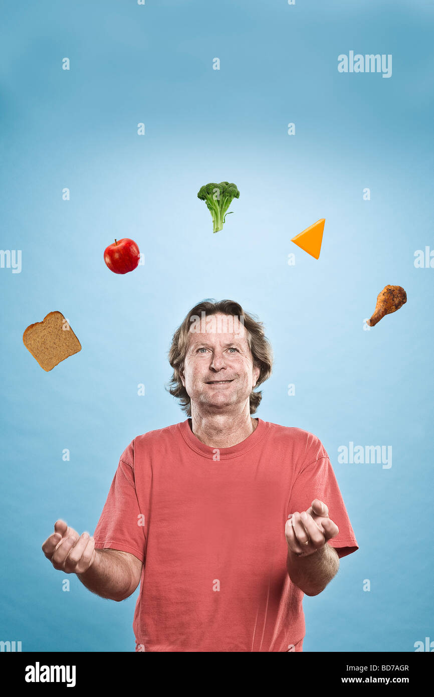 Man juggling différents aliments Banque D'Images Man juggling différents aliments Banque D'Images