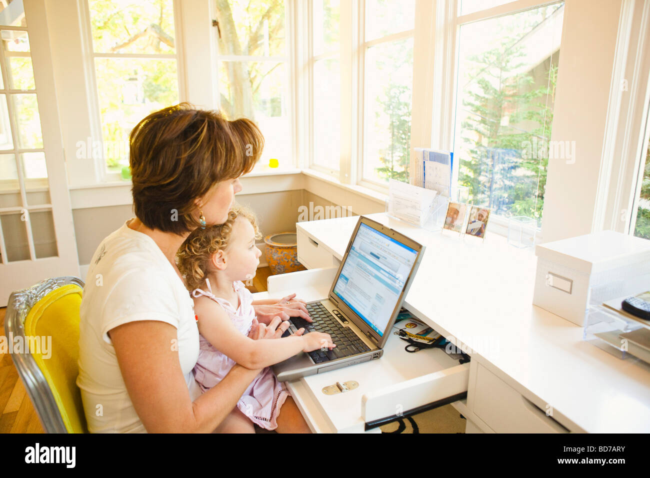 Femme avec jeune enfant in home office Banque D'Images