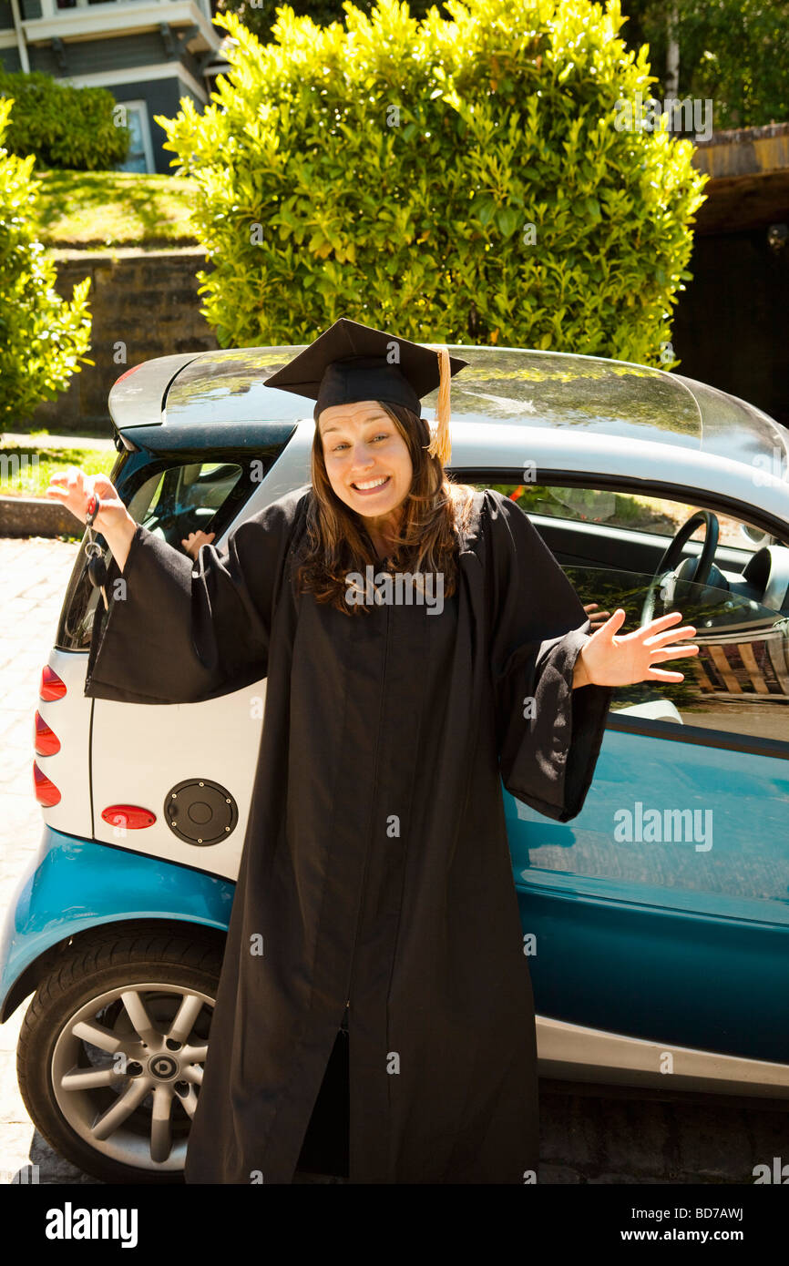 Woman in cap and gown avec smart car Banque D'Images Woman in cap and gown avec smart car Banque D'Images