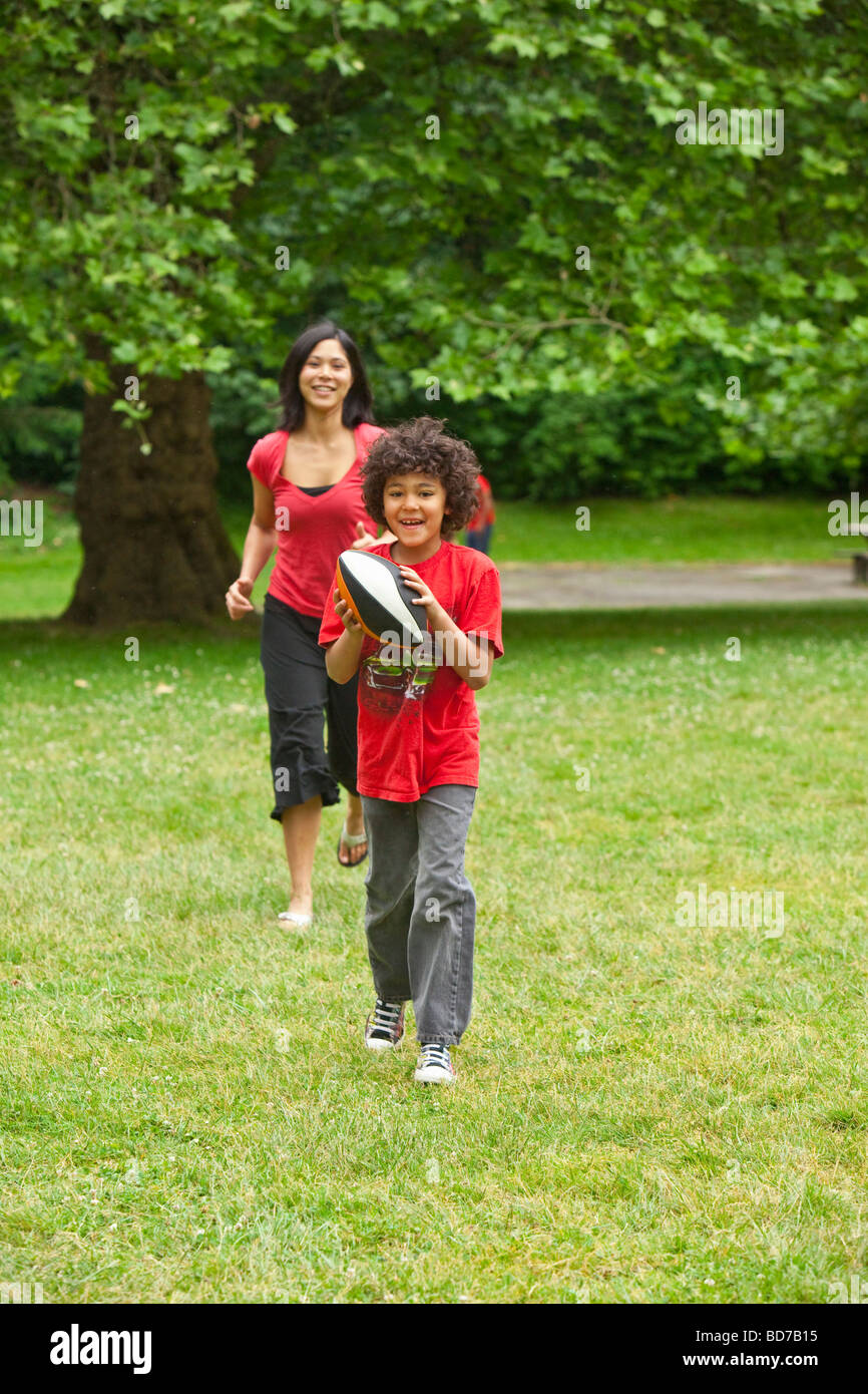 Garçon avec football allant de mère Banque D'Images