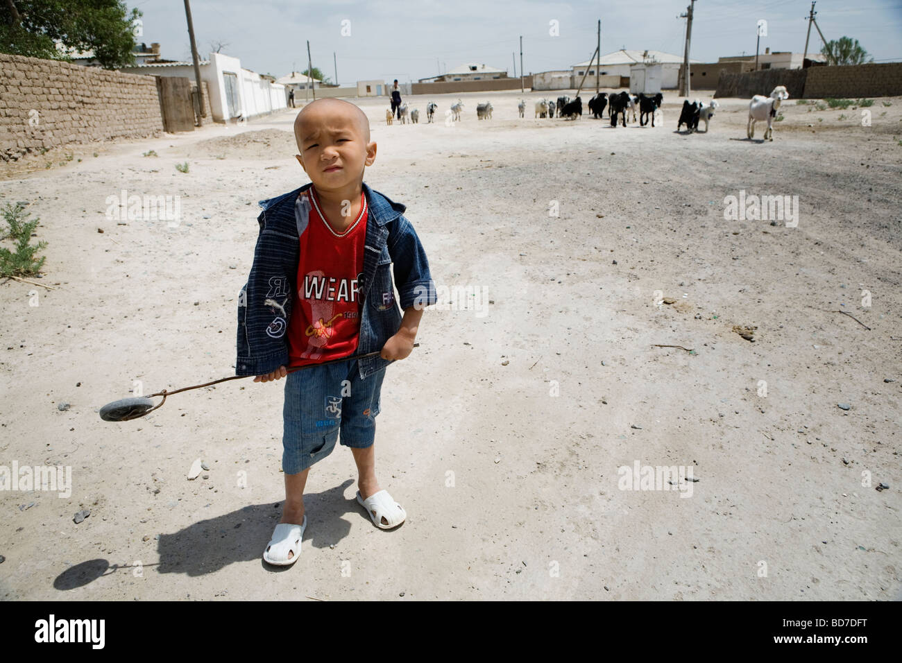 Un petit garçon jouant sur la sreet dans Moynaq, un ancien port de pêche près de la ville d'Aral, l'Ouzbékistan. Banque D'Images