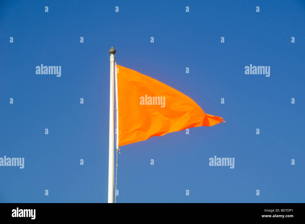 Drapeau Orange volant dans le vent dans le ciel bleu Banque D'Images