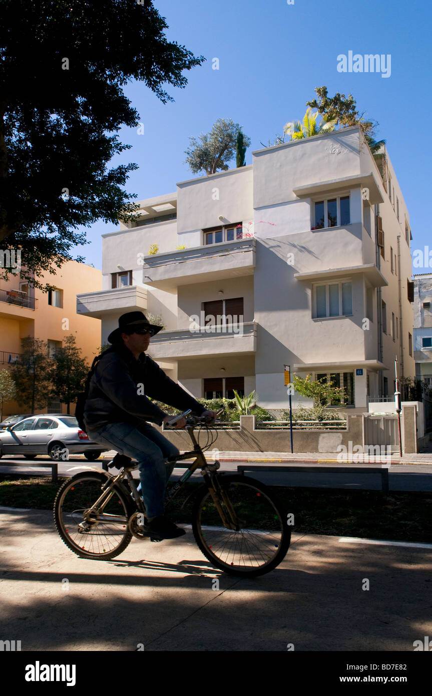 Un bicycler passer à côté d'un bâtiment de style architecture Bauhaus boulevard Rothschild dans le centre-ville de Tel Aviv ISRAËL Banque D'Images