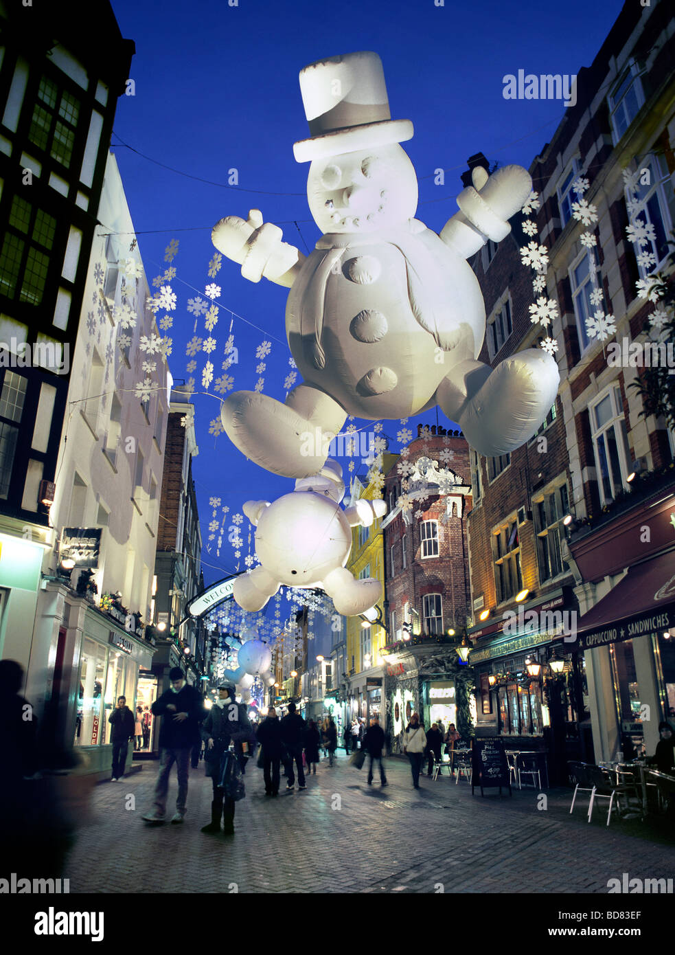 Décorations de Noël, y compris les bonshommes gonflables géants, éclairé la nuit à Carnaby Street, dans le West End de Londres. Banque D'Images