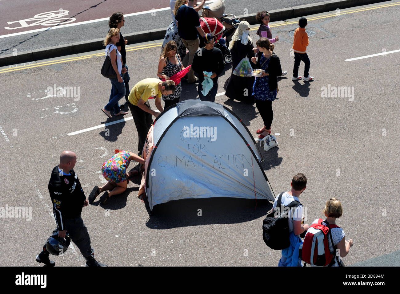 Une femme met en place une petite tente qui dit camp action climat sur maderia dur à Brighton en avant du carnaval de Brighton Banque D'Images