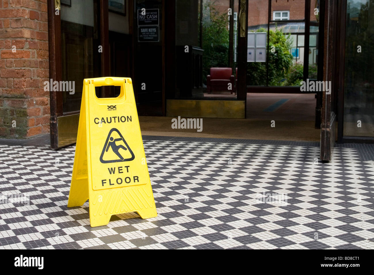 Une entrée de l'hôtel avec un sol humide surface glissante panneau de danger Banque D'Images