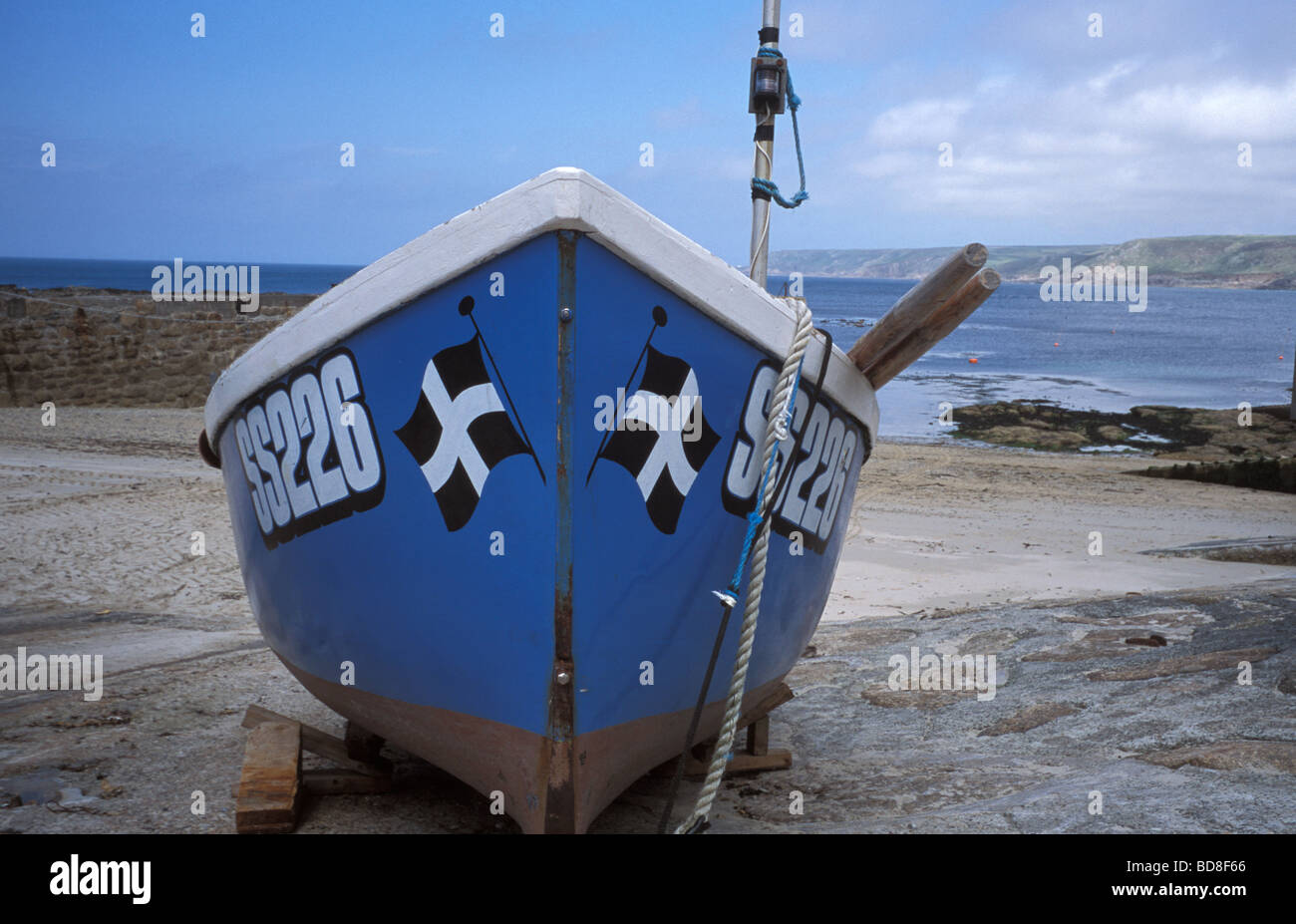 Petit bateau de pêche montrant le drapeau cornish dans le port de Sennen Cove de Cornwall sur le south west coast path Banque D'Images