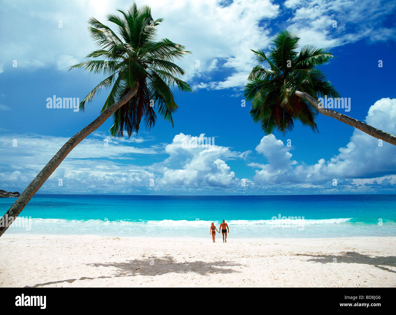 Plage de sable blanc de passage couple holding hands at Anse Intendance Beach sur l'île de Mahé aux Seychelles Banque D'Images