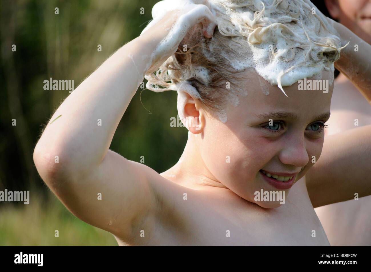 Photographie d'une jeune fille et laver ses cheveux shampooing à l'extérieur, sur une journée d'été dans le jardin britannique UK Banque D'Images