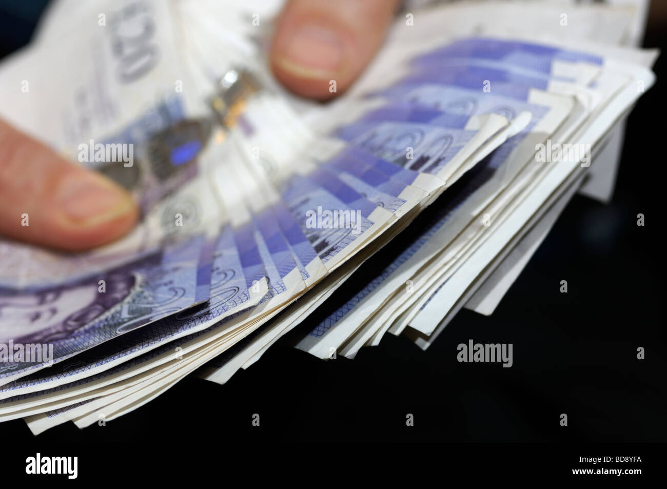 Mains tenant une liasse de billets de banque sterling britannique Banque D'Images