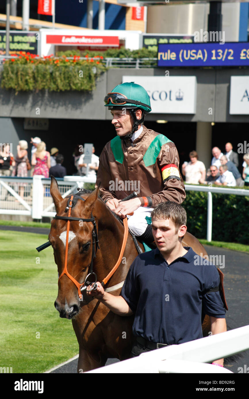 Un jockey sur son cheval à la parade à l'hippodrome d'Ascot, près de Windsor, Berkshire, Royaume-Uni. Banque D'Images