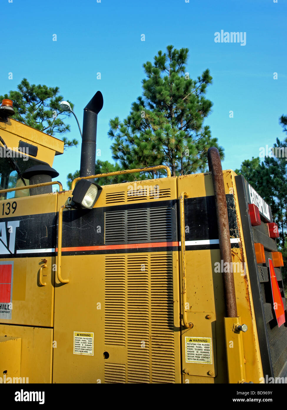L'équipement de construction et d'échappement du moteur à pile jaune avec des arbres en arrière-plan Banque D'Images
