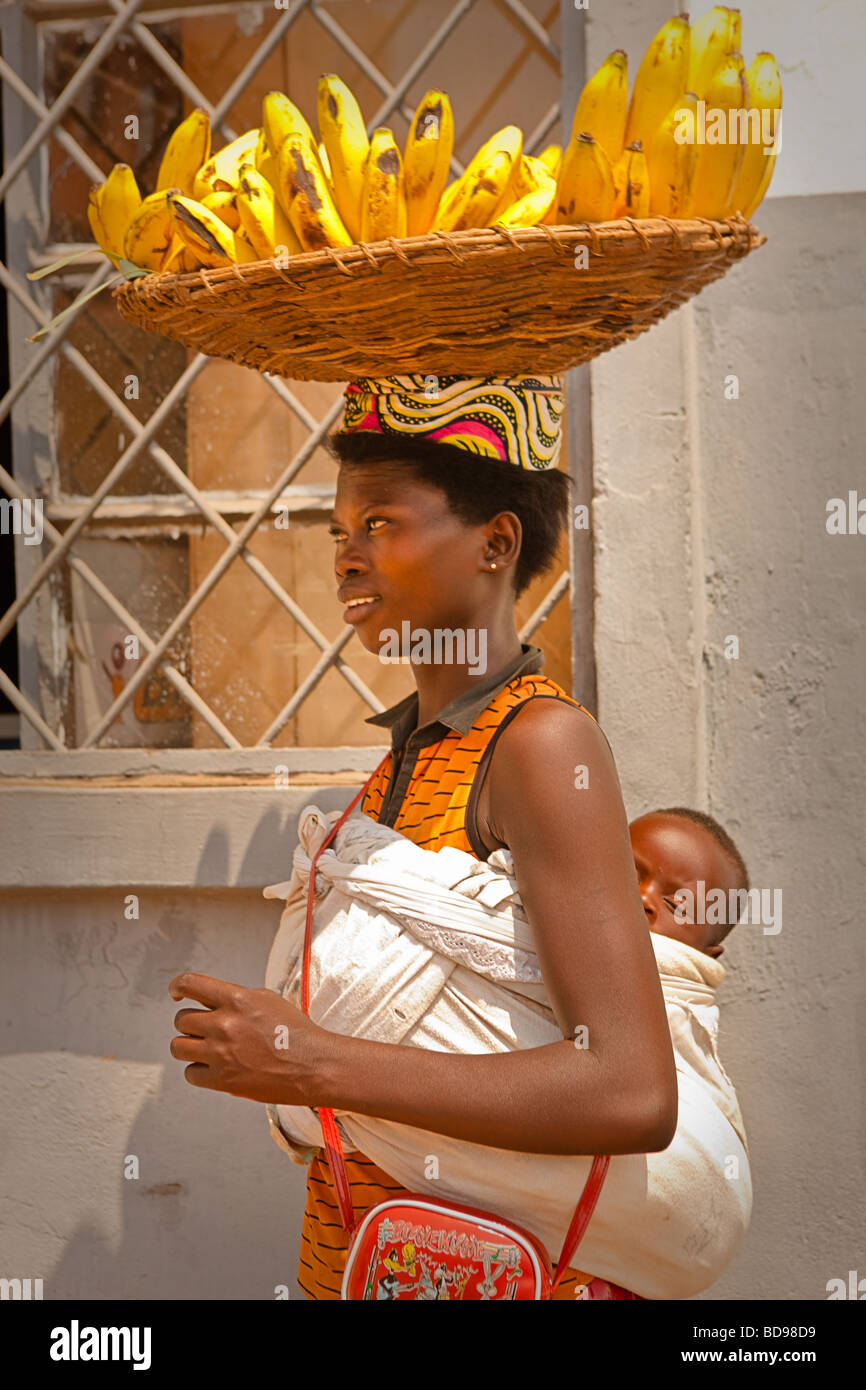 Une femme rwandaise, promenades à travers le centre-ville de Kigali la vente de bananes avec un enfant dans une écharpe sur le dos Banque D'Images