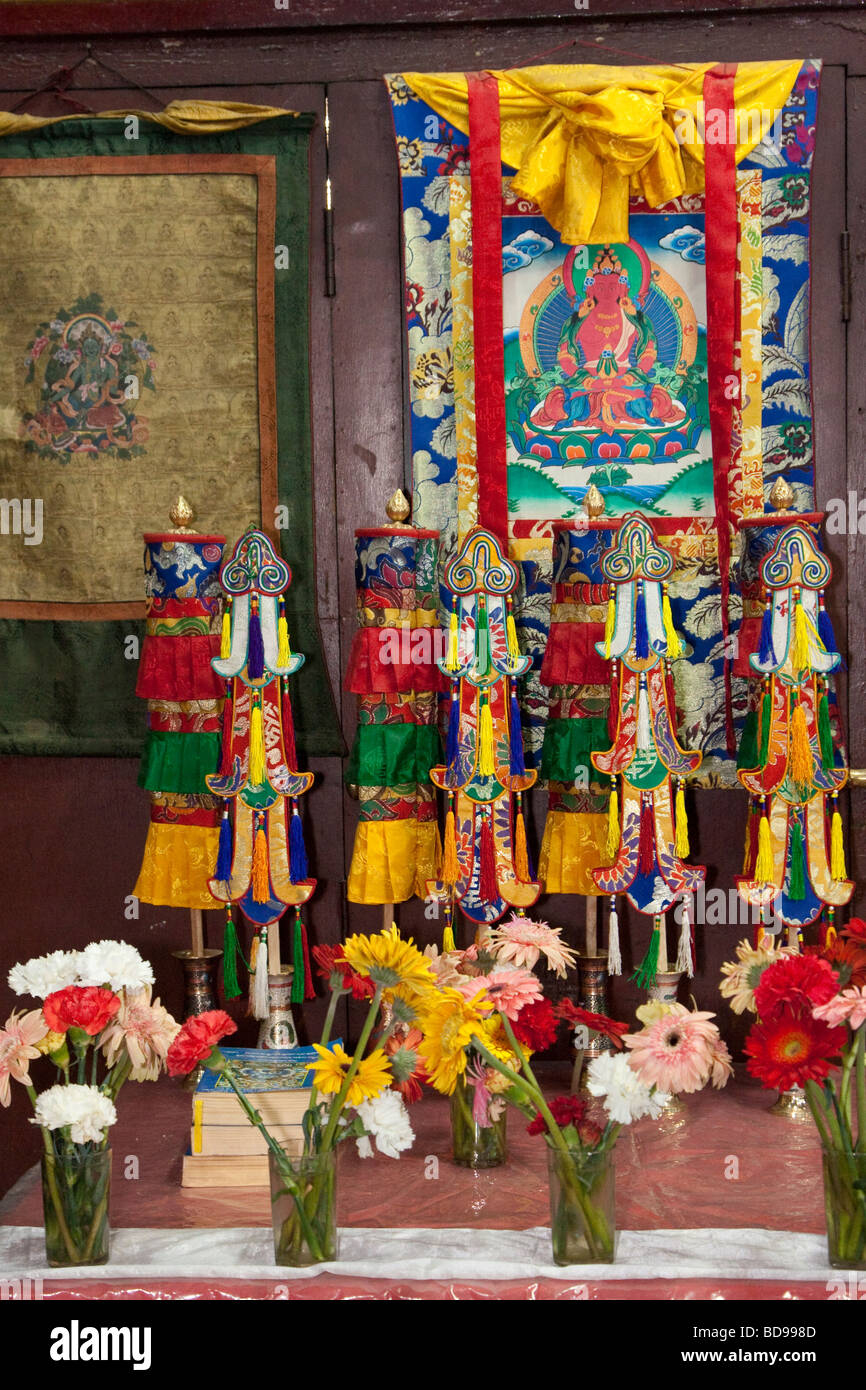 Bodhnath, au Népal. Une table à l'intérieur de l'Tsamchen Gompa (monastère). Un Thangka (peinture bouddhiste Tibétain) est suspendu sur le mur. Banque D'Images