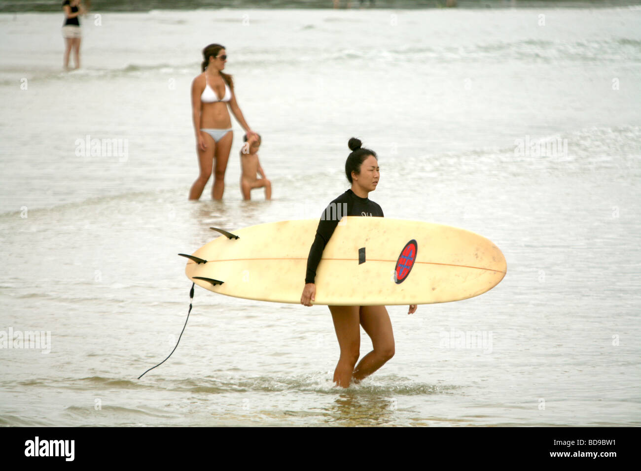 Une japonaise entre dans le surf à la note de Byron Bay en Australie Banque D'Images