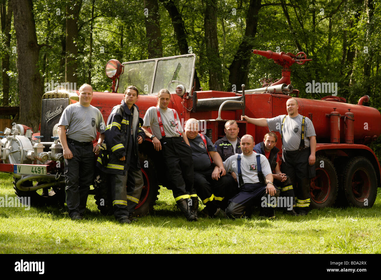 Portrait de pompiers en face de camions incendie historique Banque D'Images