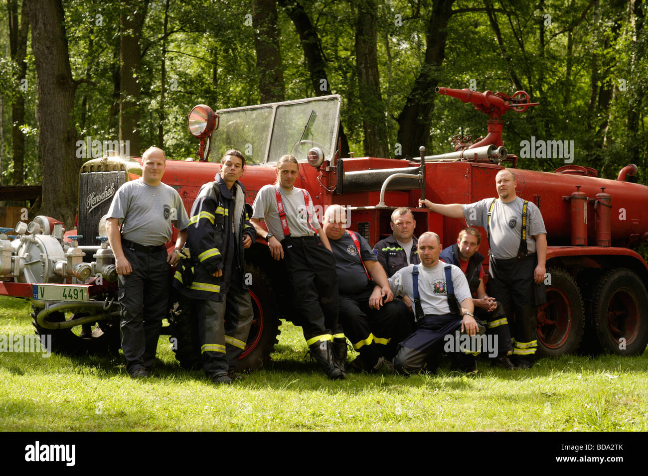 Portrait de pompiers en face de camions incendie historique Banque D'Images