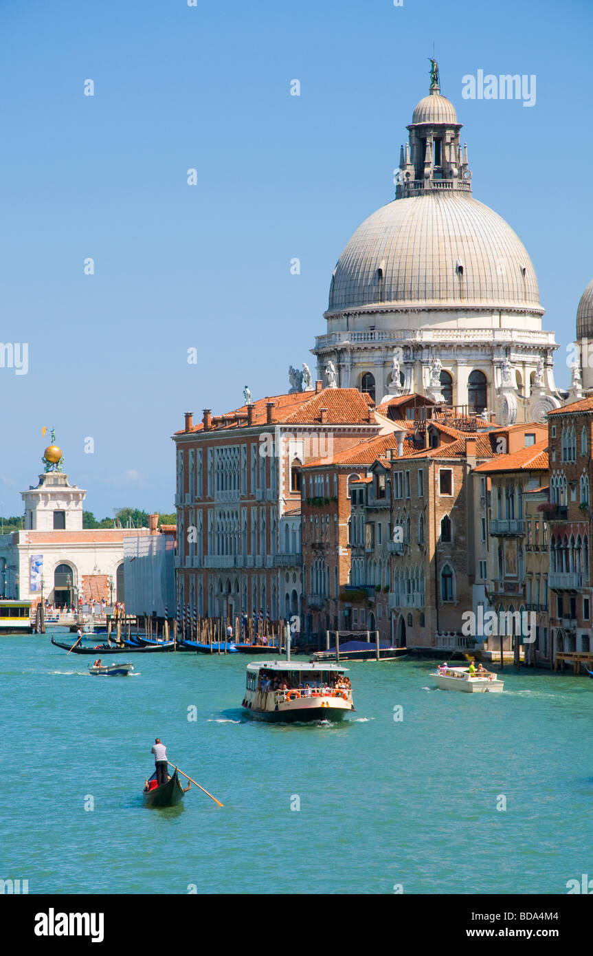 Venise, Vénétie, Italie. Église de Santa Maria della Salute et le Grand Canal vu du Ponte dell'Accademia. Vaporetto, gondole Banque D'Images