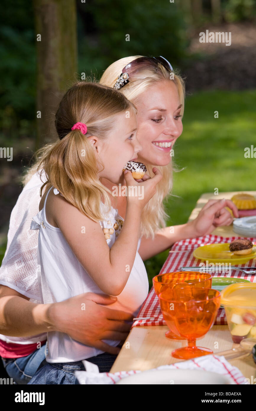 Adorable mère et fille de manger quelque chose à l'extérieur sur un jour d'été s Banque D'Images