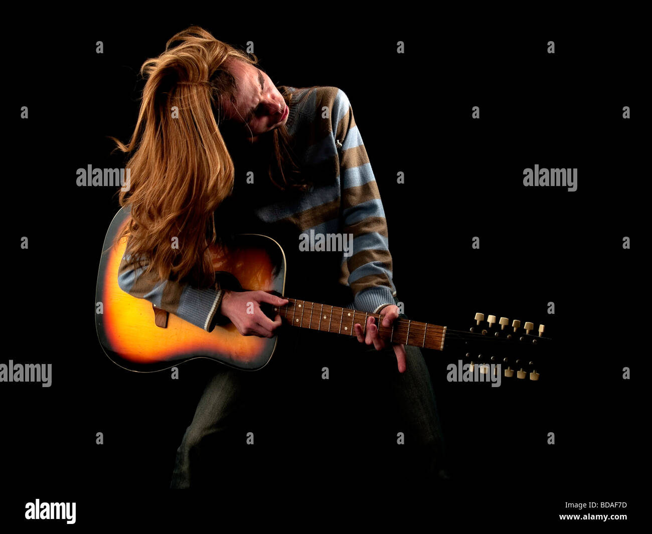Les jeunes cheveux longs joue le guitariste hard rock Banque D'Images
