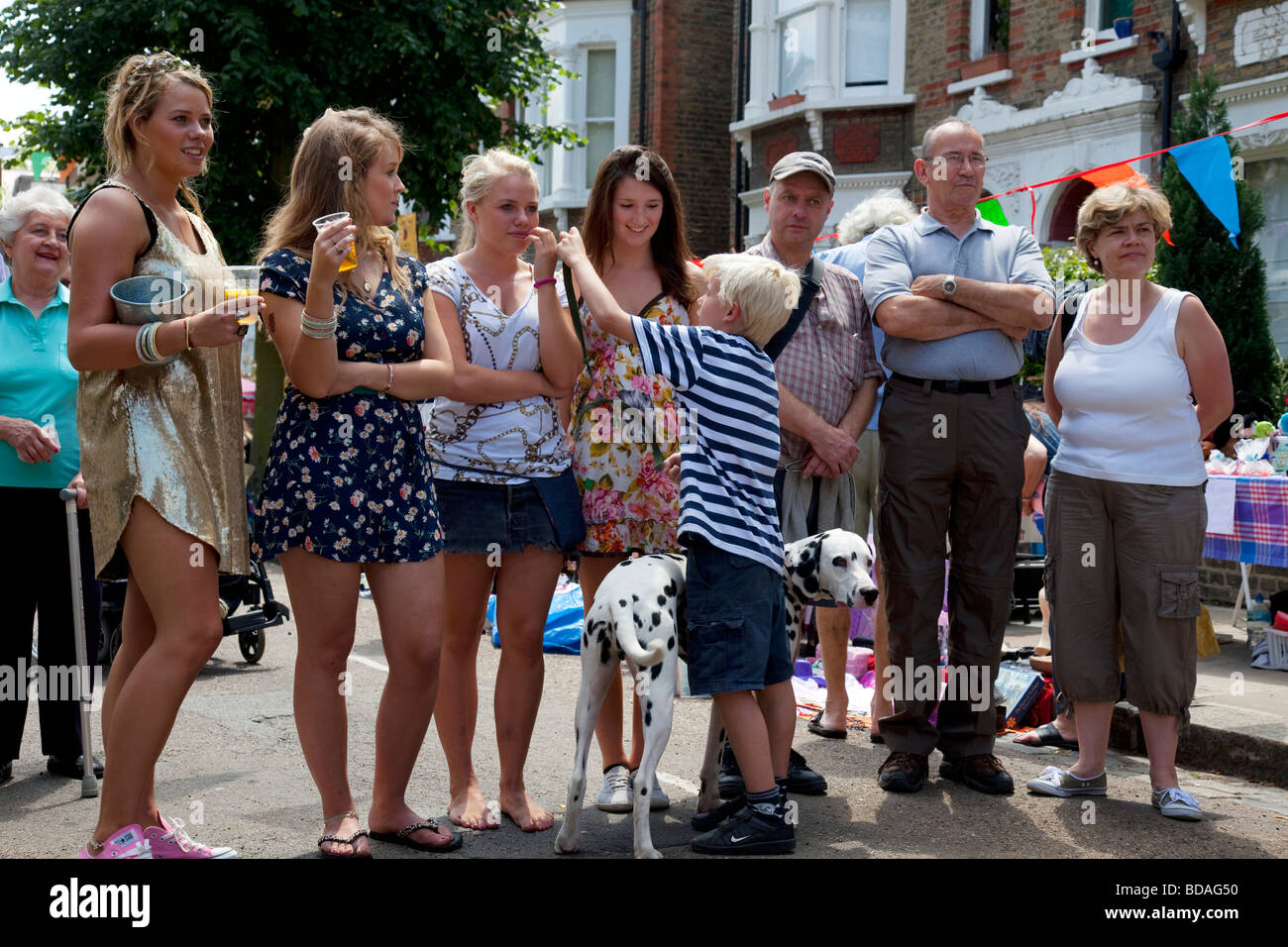 Les adolescentes un chien dalmatien et d'autres personnes lors d'une fête de rue à Hampstead, Londres. Banque D'Images