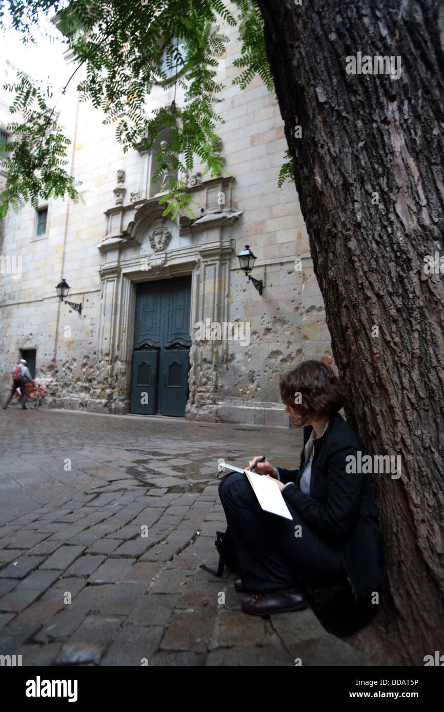 Femme assise sous un arbre sur la place de la Placa San Felipe de Neri dans la ville de Barcelone en Espagne Banque D'Images