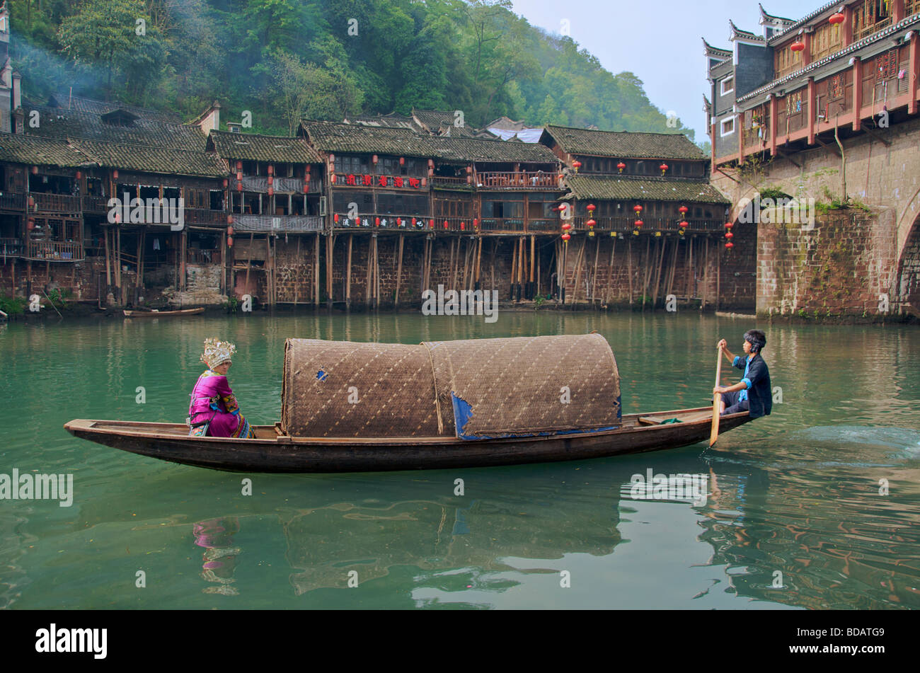 Bateau à rames couvertes avec fille en costume de la minorité sur Tuo Rivière à Hong Qiao Bridge ancienne ville de Fenghuang Chine Hunan Banque D'Images